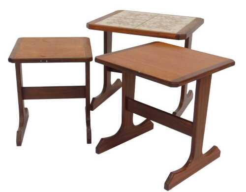 A nest of three G-Plan teak tables, each raised on outsplayed united by a stretcher, one with a...