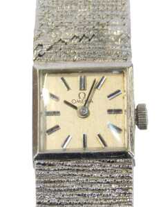 An Omega 9ct white gold lady's wristwatch, the silvered square watch head with baton dial, and...