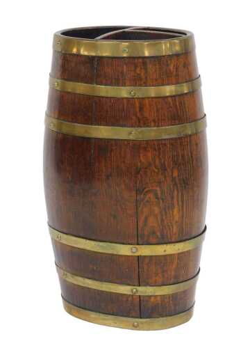 An oak barrel umbrella and stick stand, with brass banding and three division section to the top,...