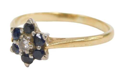 A sapphire and diamond floral cluster ring, the round brilliant cut diamond surrounded by six...
