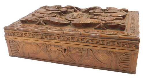 A 20thC Eastern hardwood cigar or cigarette box, carved with dragons and decorated centrally...