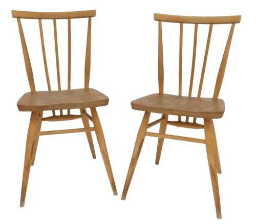 A pair of elm Ercol style stickback kitchen chairs, each with a solid seat, raised on...