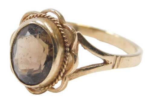 A 9ct gold and smokey quartz dress ring, set with an oval smokey quartz, in oval setting, on a...