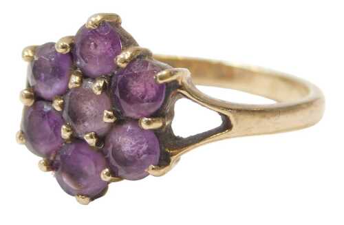 A 9ct gold and amethyst dress ring, the floral cluster head set with seven round brilliant cut...