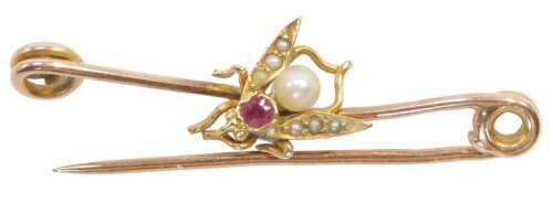 An Edwardian fly brooch, set with a ruby and seed pearls, on a yellow metal pin stamped 9ct, 4cm...