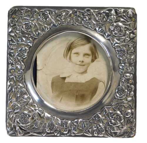 An Edward VII silver embossed photograph frame, of square form, decorated with flowers, the...