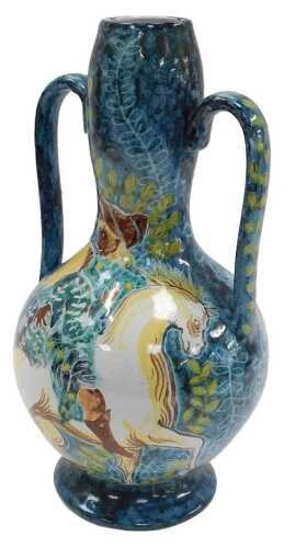A two handled studio pottery vase, decorated with a figure on horseback with a lady, in shades...
