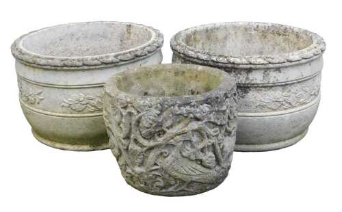 A pair of composition stone garden planters, each of cylindrical form, decorated with floral...