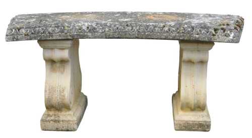 A composition stone garden bench, the arched seat with a gadrooned border, raised on scrolling...