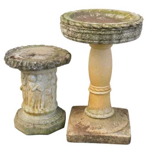 A composition stone garden birdbath, the circular top decorated with a band of leaves, on a...