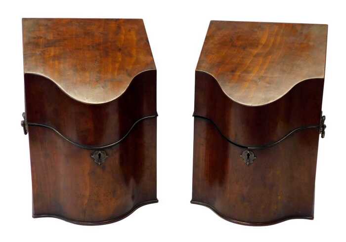 A pair of George III mahogany knife boxes, each of serpentine form, the hinged lid opening to...
