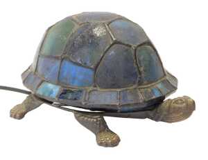 A Tiffany style tortoise table lamp, the shell in shades of blue and green glass, on a cast...