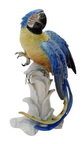 A Karl Ens porcelain figure modelled as a parrot, in a blue and yellow colourway, mounted on a...