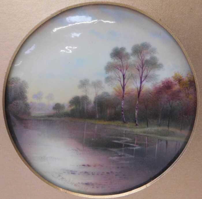 A Paragon porcelain plaque, painted with a river landscape, by F Micklewright, 12cm diameter, in...