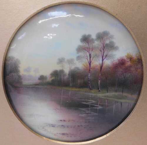 A Paragon porcelain plaque, painted with a river landscape, by F Micklewright, 12cm diameter, in...