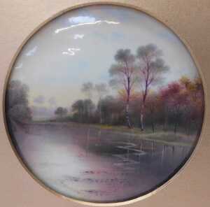 A Paragon porcelain plaque, painted with a river landscape, by F Micklewright, 12cm diameter, in...