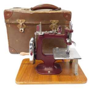 A mid century child's hand operated sewing machine, in purple, 20cm high, cased. - 2
