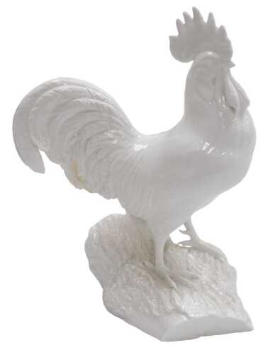 A Royal Crown Derby blanc-de-chine porcelain figure of a cockerel, modelled perched on a log,...