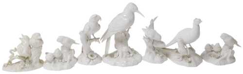 A group of Royal Crown Derby blanc-de-chine porcelain figures of birds, including a woodpecker,...