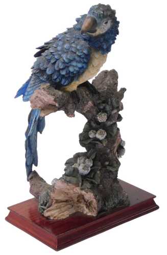 A resin figure of a Macaw, possibly Montefiori, raised on a wooden base, 40cm high.