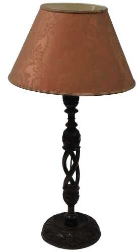 An early 20thC Alpine wooden table lamp, carved with flowers and leaves, with a shade, 81cm high.