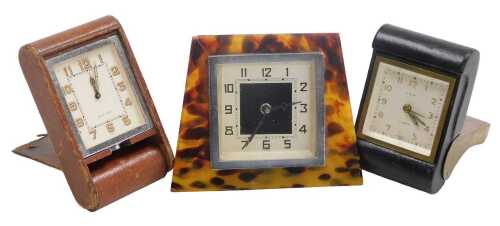 An early 20thC Jaeger LeCoultre tank leather bound travelling clock, an LSM leather bound travel...
