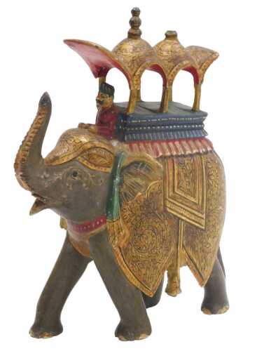 An early 20thC Indian papier mache figure of an elephant, ridden by a man beneath a hoodah,...