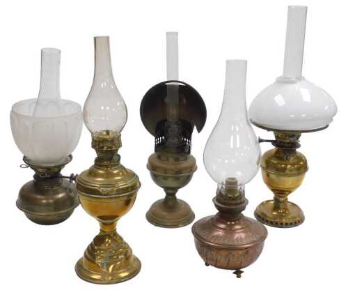 Five Victorian and later brass and copper oil lamps, with chimneys, three with shades.