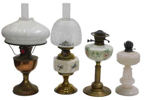 Three Victorian and later glass oil lamps, one with a ceramic reservoir printed with birds, two...