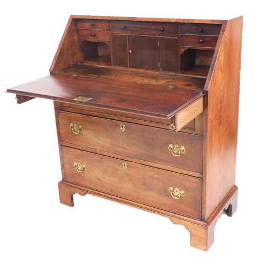 A George III mahogany bureau, with rosewood crossbanding, the fall opening to reveal a central...