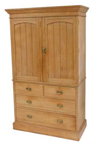 A Victorian ash linen press, the outswept pediment over a pair of panelled doors opening to...