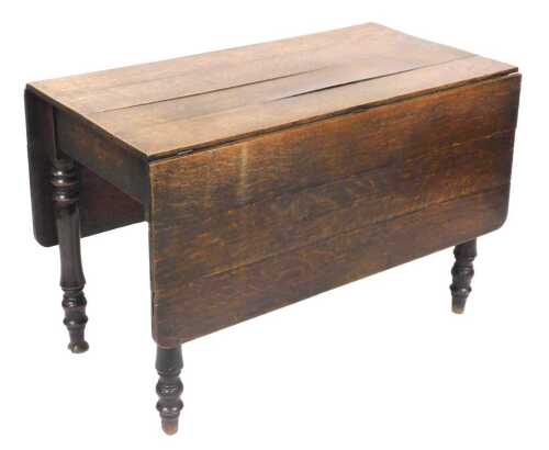 A late Georgian oak drop leaf dining table, raised on turned legs, 71cm high, 106.5cm wide,...