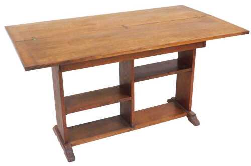 An early 20thC oak table bookcase, with a foldover top above a rectangular section, with two...