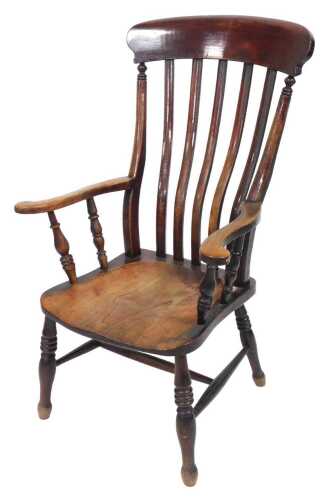 A Victorian oak and elm lath back kitchen chair, raised on turned legs, united by an H frame...