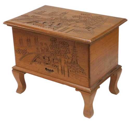 A mid century camphorwood sewing box, the lid carved with three figures on a bridge on a river...