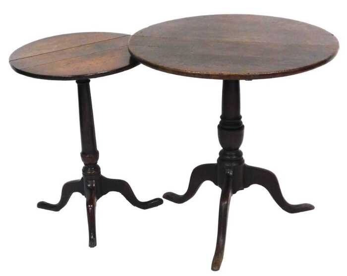 A George III oak tilt top occasional table, the circular top raised on a turned column over...