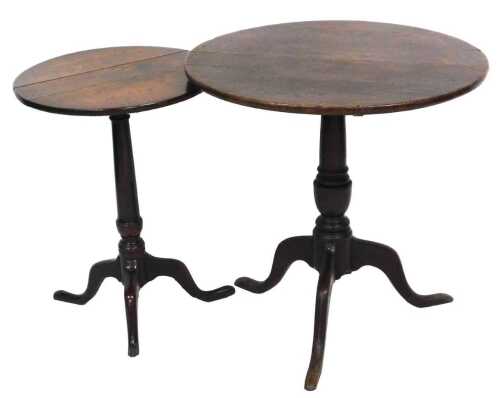 A George III oak tilt top occasional table, the circular top raised on a turned column over...