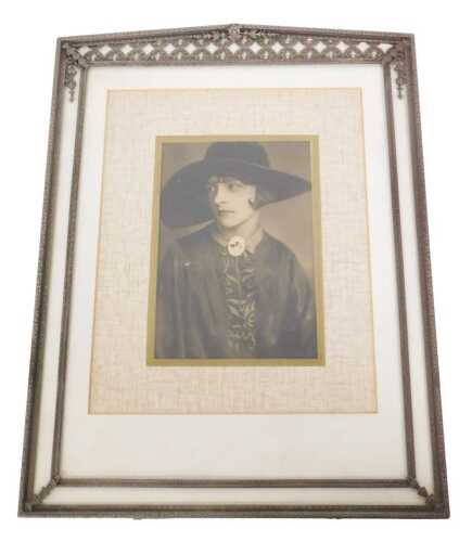 An early 20thC white metal easel backed photograph frame, with pierced border and flowerhead and...