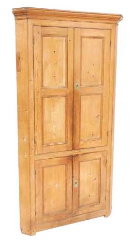 An early 19thC stripped pine standing corner cabinet, with a moulded cornice above two panelled...