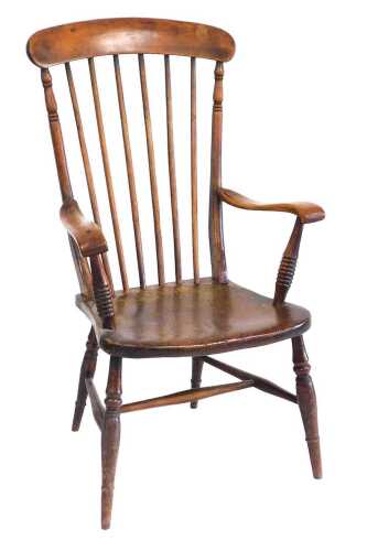 A 19thC ash and elm country armchair, with spindle turned back, shaped arms and a solid seat, on...