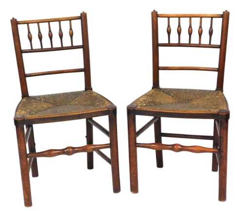 A pair of 19thC fruitwood and ash side chairs, each with a spindle turned back, a rush seat on...