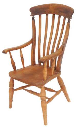 A Victorian oak and elm lath back kitchen chair, with a solid saddle seat, raised on turned legs...