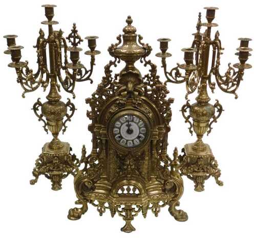A Continental brass clock garniture, the dial with enamel Roman numerals around a painted centre,...