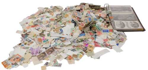 Philately. Two bags containing a large number of world loose stamps, and a postcard album...
