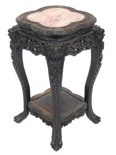 A late 19thC Chinese hardwood urn stand, the carved quatrelobe top inset with red and white...