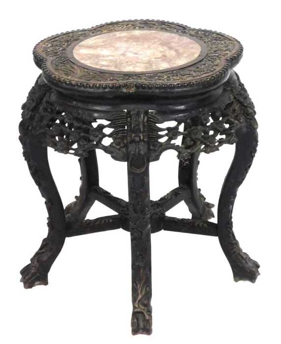 A late 19thC Chinese hardwood urn stand, with a cinquefoil top carved with flowers and bamboo,...