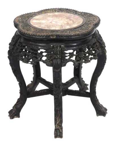 A late 19thC Chinese hardwood urn stand, with a cinquefoil top carved with flowers and bamboo,...