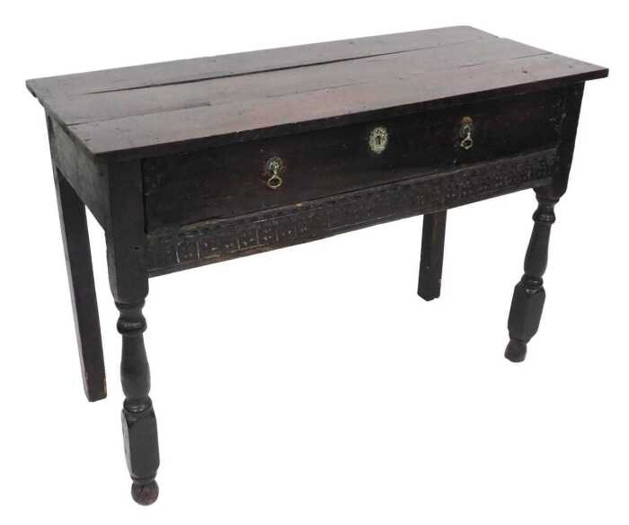 A 17thC oak serving table, with a triple plank top, above one long drawer over a frieze carved...