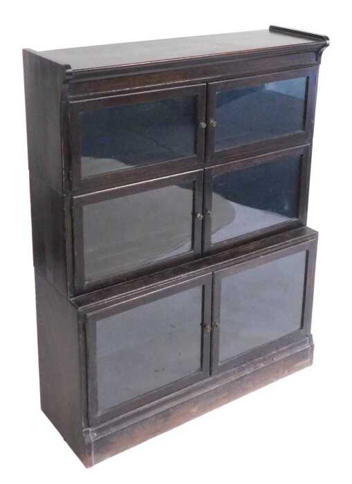 A Victorian Globe Wernicke style oak bookcase, the upper section with four glazed doors...