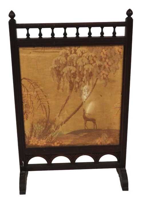A Victorian mahogany framed fire screen, set with a silk panel, decorated with a deer in a...